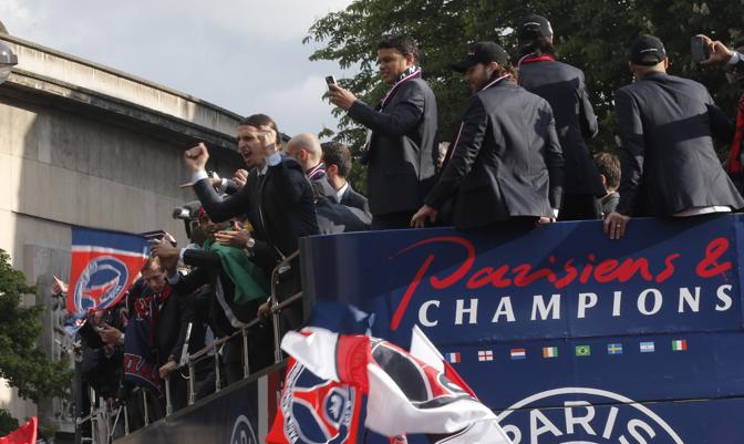 Ibrahimovic festeggia coi tifosi mentre Thiago Silva scatta foto col cellulare dal pullman. Ap